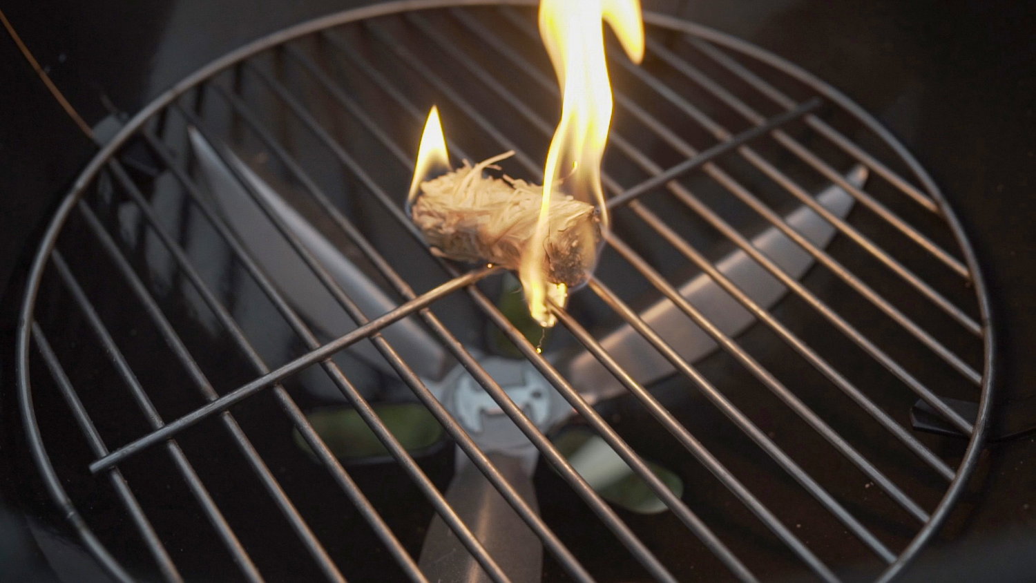 Tændblok på rund kulgrillrist Brændende tændblok på metalgrillrist