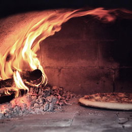 Pizza bages i traditionel stenovn Brændefyret stenovn med pizza på sten